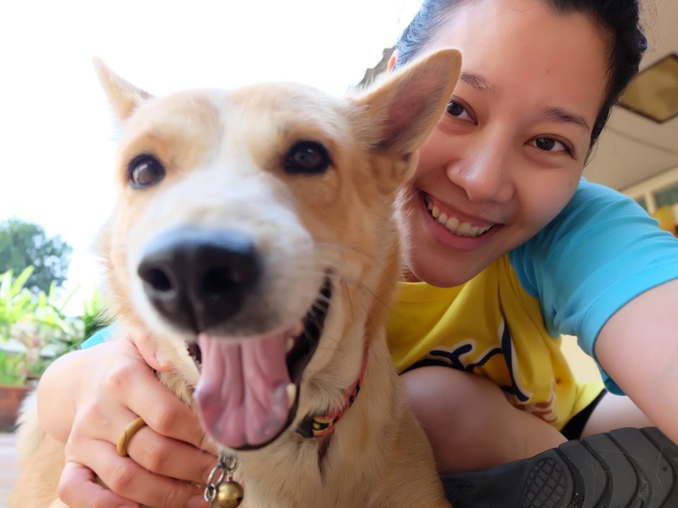 Woman holding dog smiling