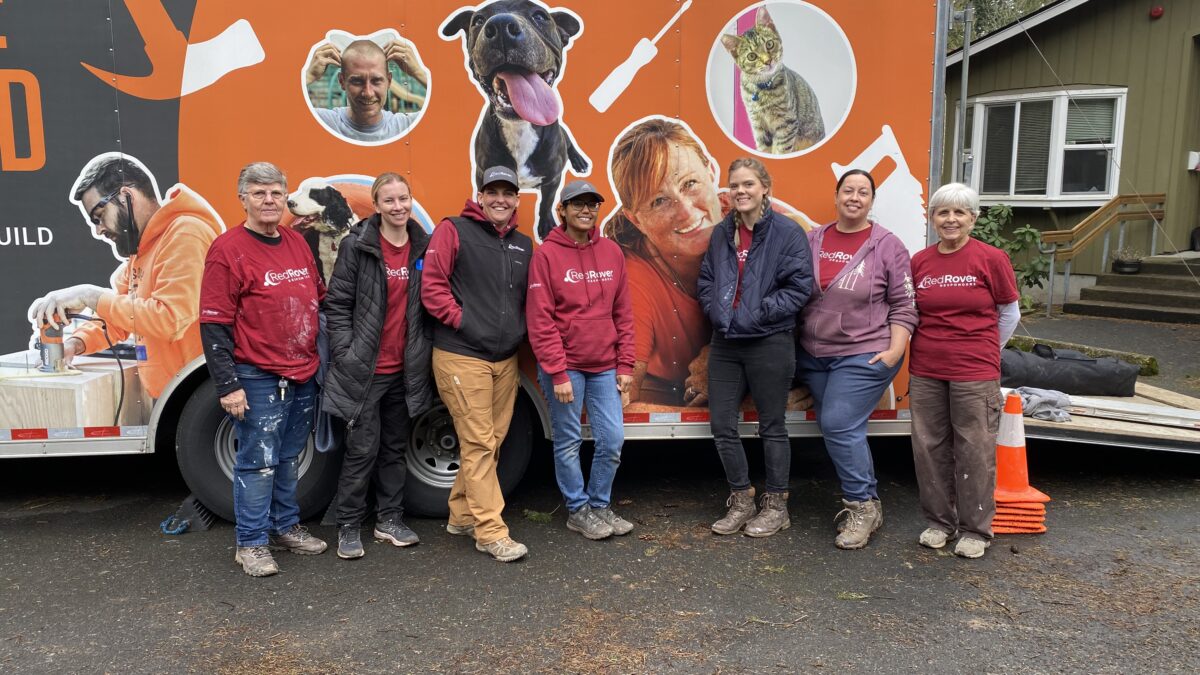A group of RedRover Responders volunteers and staff pose in front of the Rescue Rebuild truck during a deployment