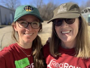 two women wearing RedRover Responders shirts, glasses, and hats