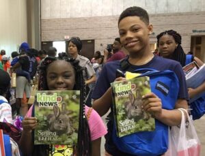 two children holding Kind News magazine in Macon, GA