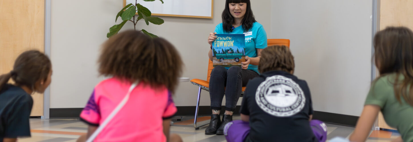 Woman with RedRover Readers reads book to children