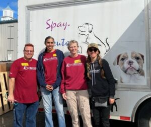 RedRover volunteers and staff Beth and Devon stand in front of a mobile pet assistance truck