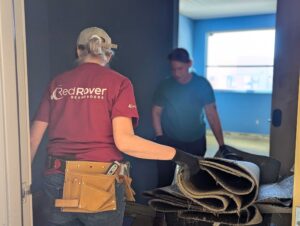 A RedRover Responders volunteer and Purina team member carries in flooring to a domestic violence shelter