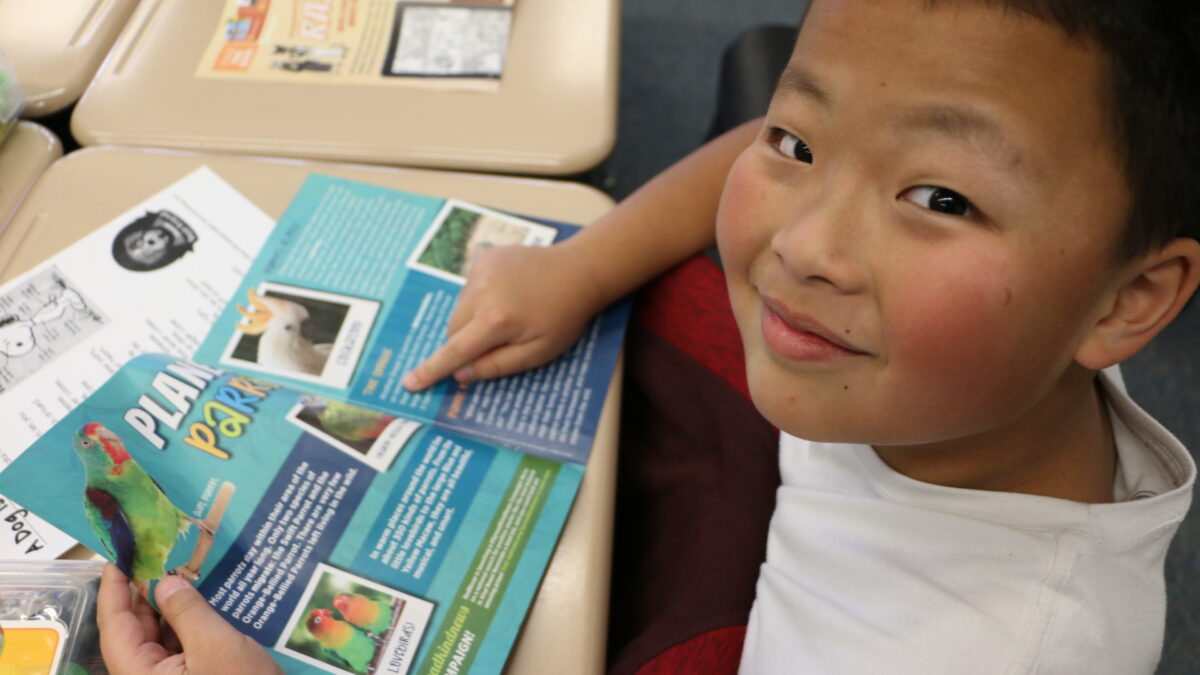 Classroom kid reads Kind News magazine