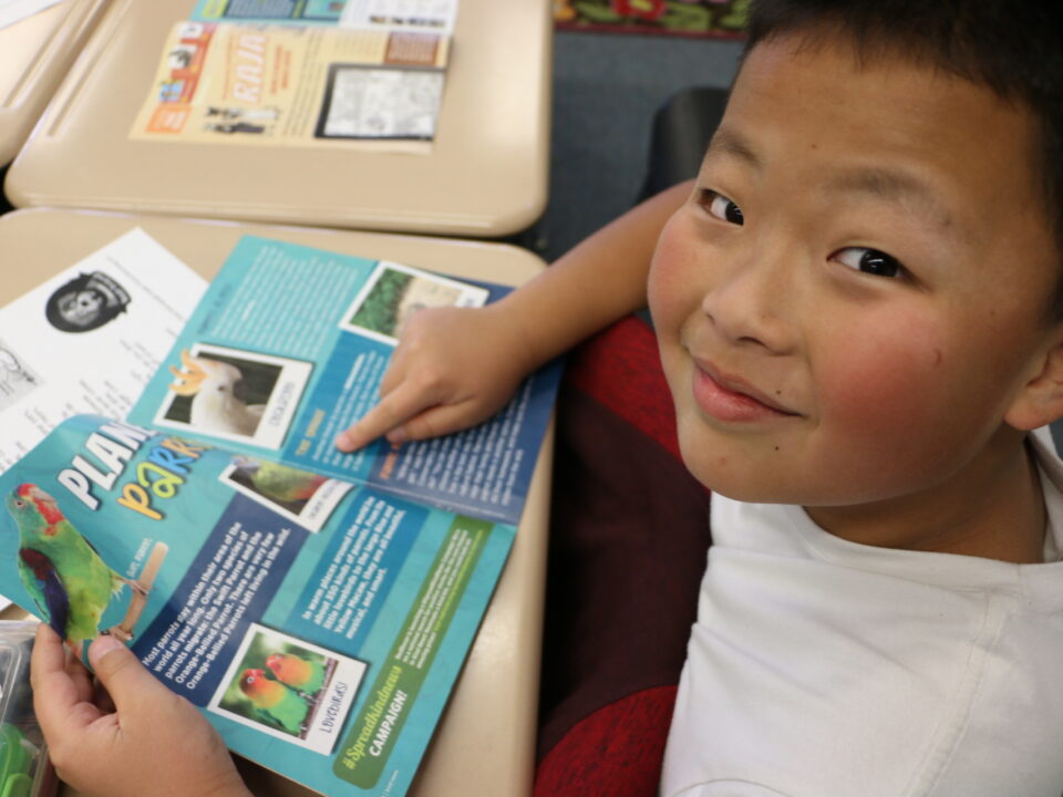 Classroom kid reads Kind News magazine