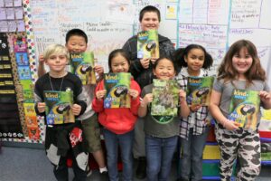 Classroom kids pose with Kind News magazine