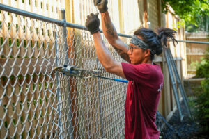 RedRover Responders volunteer Jojo helps build fencing at the YWCA domestic violence shelter in Cincinnati, Ohio