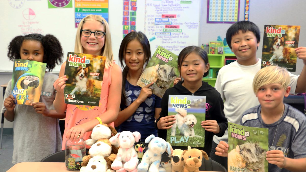 Classroom kids holding Kind News magazine