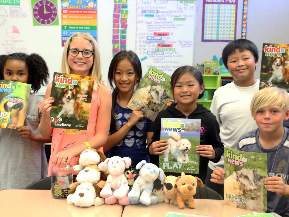 Classroom kids holding Kind News magazine