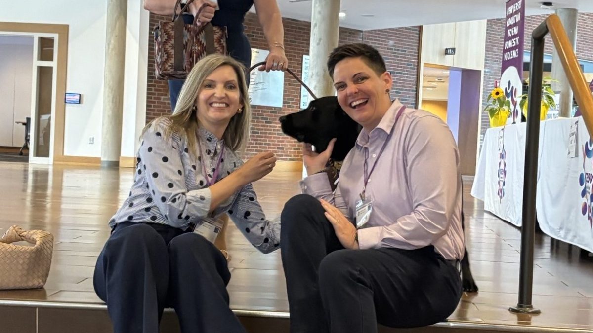 RedRover President and CEO Katie Campbell with a dog and colleagues at NJCEDV