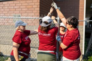 RedRover Responders volunteers install chain-link fencing at a domestic violence shelter build