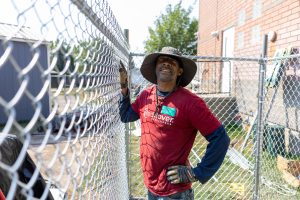 RedRover Responders volunteers install chain-link fencing at a domestic violence shelter build